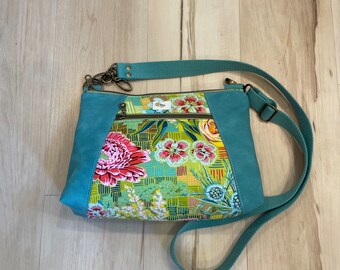 Sunshine Crossbody bag in springtime florals with aqua faux leather accents.