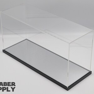 K&ouml;nnte beinhalten: Eine transparente Acryl-Vitrine mit schwarzem Sockel und einem verspiegelten Boden. Die Vitrine ist leer.