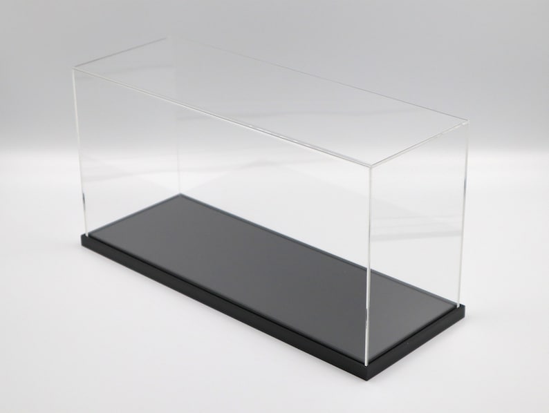Puede incluir: Una vitrina de exhibici&oacute;n de acr&iacute;lico transparente con una base negra. La vitrina est&aacute; vac&iacute;a y tiene una forma rectangular.