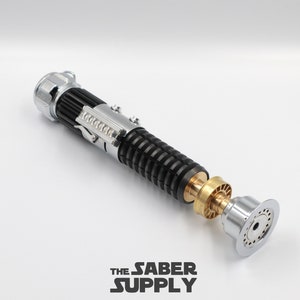 May include: A black and silver lightsaber with a gold accent. The lightsaber is disassembled and the parts are laid out on a white surface. The lightsaber is a popular collectible for fans of the Star Wars franchise.