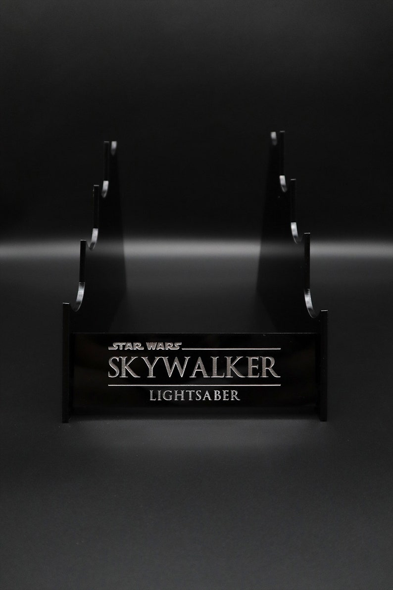 May include: Black plastic stand with five slots for displaying lightsabers. The stand has the text "STAR WARS SKYWALKER LIGHTSABER" printed on the front.