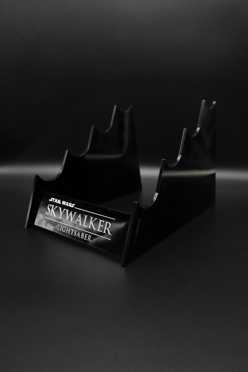 May include: Black acrylic lightsaber stand with the text "STAR WARS SKYWALKER LIGHTSABER" on the front.
