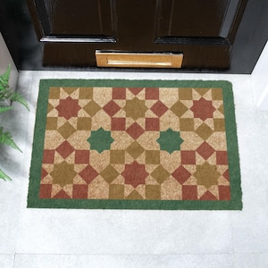 May include: A brown coir doormat with a geometric pattern of red, green, and brown stars and squares. The doormat has a green border.