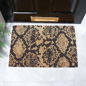 May include: A rectangular doormat featuring a snakeskin design in brown and black. The mat is made from natural fibres and is positioned in front of a black door with a letterbox.