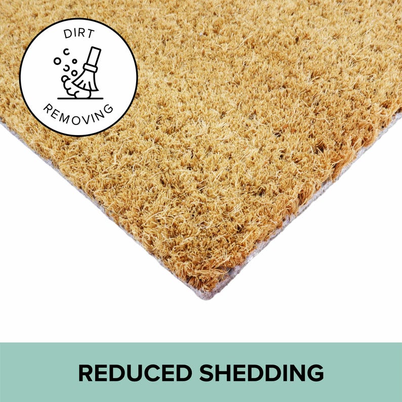 May include: A rectangular doormat made of natural fibers, with a light brown color. A white circle with a black illustration of a broom sweeping dirt is in the upper left corner. The text "DIRT REMOVING" is around the circle. The words "REDUCED SHEDDING" are at the bottom.