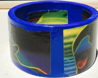 Bright blue flat cuff bangle with decoupage detail from the art of Ed Paschke