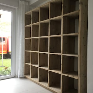May include: A large wooden bookcase with multiple shelves. The bookcase is made of natural wood with a light brown finish. The shelves are empty and ready to be filled with books or other items.