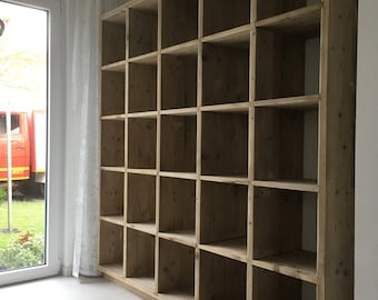 Puede incluir: Una gran estantería de madera con múltiples estantes. La estantería está hecha de madera natural con un acabado marrón claro. Los estantes están vacíos y listos para ser llenados con libros u otros artículos.