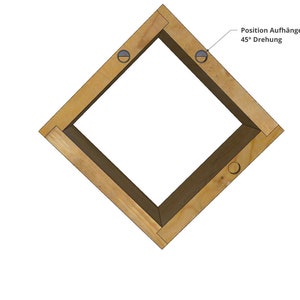 May include: A wooden square frame with two holes drilled into the top corners. The frame is angled at 45 degrees and the text "Position Aufh&auml;nger 45&deg; Drehung" is written above the frame.