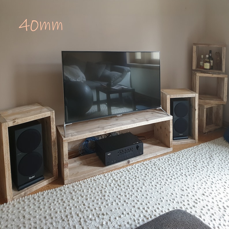 Puede incluir: Un centro de entretenimiento de madera con un televisor de pantalla plana, dos altavoces y un receptor est&eacute;reo. El centro de entretenimiento tiene tres estantes y est&aacute; hecho de madera recuperada. La televisi&oacute;n mide 40 mm.