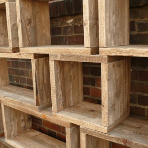 May include: A set of wooden shelves with a rustic, weathered finish. The shelves are stacked in a staggered pattern, creating a unique and interesting design. The shelves are made of natural wood and have a warm, inviting feel.