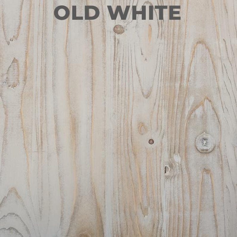 Puede incluir: Primer plano de una superficie de madera envejecida con un acabado blanco desgastado. La veta de la madera es visible, con nudos e imperfecciones que a&ntilde;aden encanto r&uacute;stico. El texto "OLD WHITE" est&aacute; impreso en la parte superior.