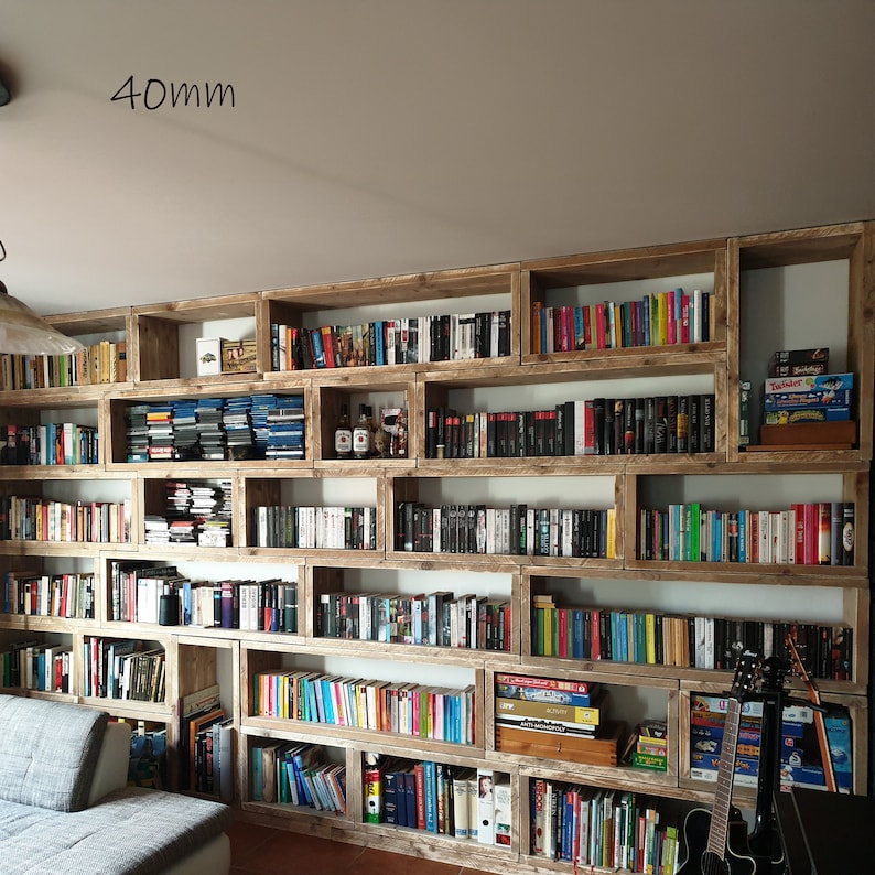 Puede incluir: Una gran estanter&iacute;a de madera con m&uacute;ltiples estantes llenos de libros. Los estantes est&aacute;n dispuestos en forma de cuadr&iacute;cula y est&aacute;n hechos de madera reciclada. La estanter&iacute;a tiene 40 mm de grosor.