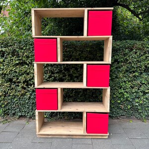 Op de afbeelding: Een houten plank met vijf planken en zes rode opbergdozen. De plank is gemaakt van natuurlijk hout en heeft een rustieke uitstraling.