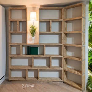 Puede incluir: Una estanter&iacute;a de madera con m&uacute;ltiples estantes y compartimentos. Los estantes est&aacute;n vac&iacute;os, excepto por una peque&ntilde;a planta en maceta y algunos libros. La estanter&iacute;a est&aacute; hecha de madera natural con un acabado marr&oacute;n claro. El texto "24mm" es visible en la parte inferior de la imagen.