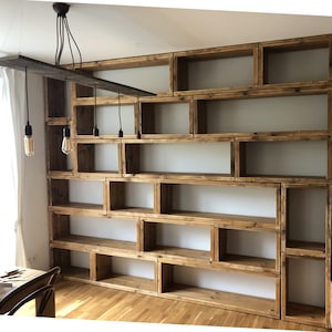 May include: A rustic wooden bookshelf with multiple shelves and compartments. The shelves are made of reclaimed wood and have a natural, unfinished look. The bookshelf is perfect for displaying books, plants, or other decorative items.