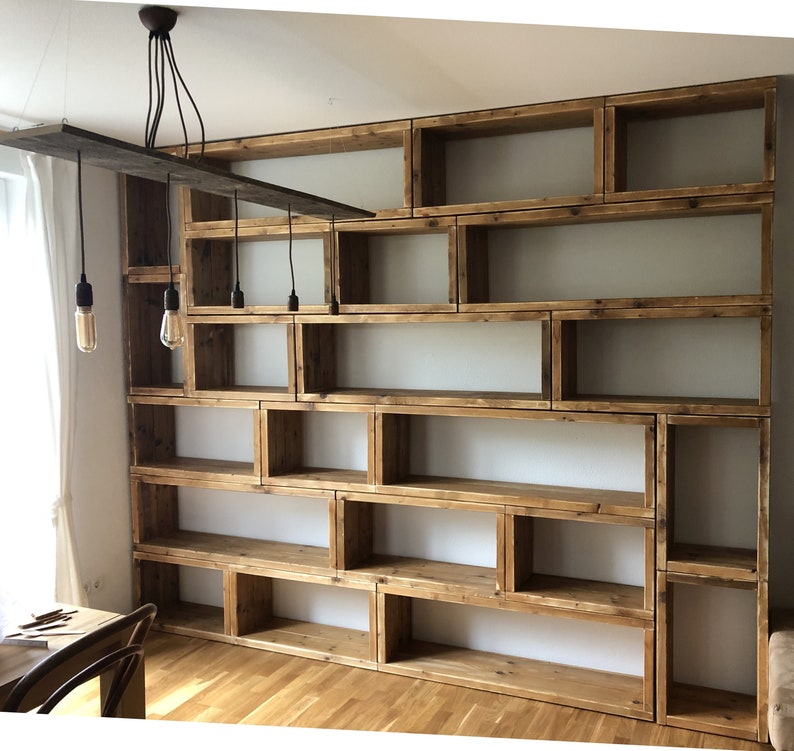 May include: A rustic wooden bookshelf with multiple shelves and compartments. The shelves are made of reclaimed wood and have a natural, unfinished look. The bookshelf is perfect for displaying books, plants, or other decorative items.