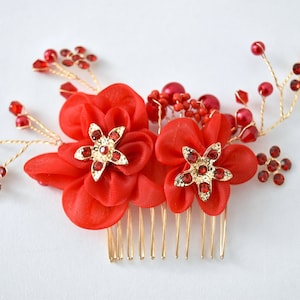 May include: Red and gold hair comb with two fabric flowers, each with a jeweled center. The comb has a gold wire design with red beads and rhinestones.