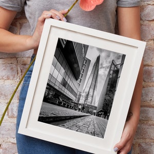 May include: A black and white photograph of the Shard, a skyscraper in London, England, framed in a white frame.