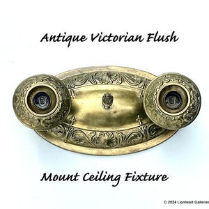 May include: Antique Victorian flush mount ceiling fixture made of brass with ornate floral designs. The fixture has two decorative covers with a central finial.