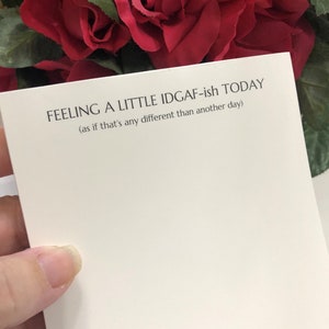 May include: A white card with the text "FEELING A LITTLE IDGAF-ish TODAY (as if that's any different than another day)" printed in black.