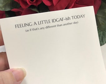 May include: A white card with the text "FEELING A LITTLE IDGAF-ish TODAY (as if that's any different than another day)" printed in black.