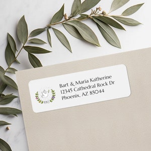 May include: A white return address label with a dove and olive branch design. The text reads "Bart & Maria Katherine 12345 Cathedral Rock Dr Phoenix, AZ 85044".