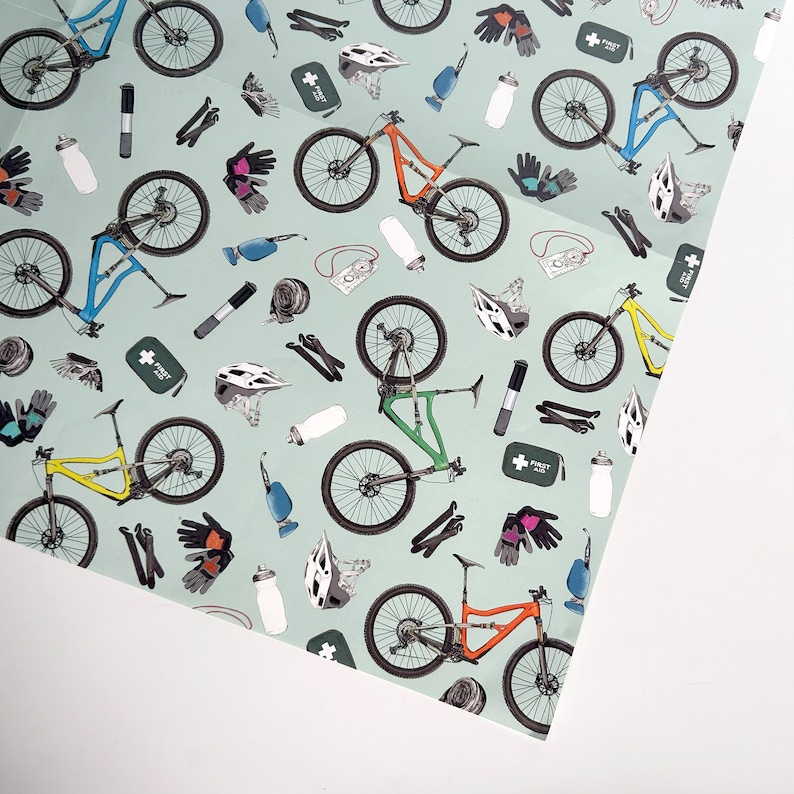 May include: A green and blue repeating pattern of mountain bikes, helmets, water bottles, first aid kits, and other cycling accessories on a light blue background.