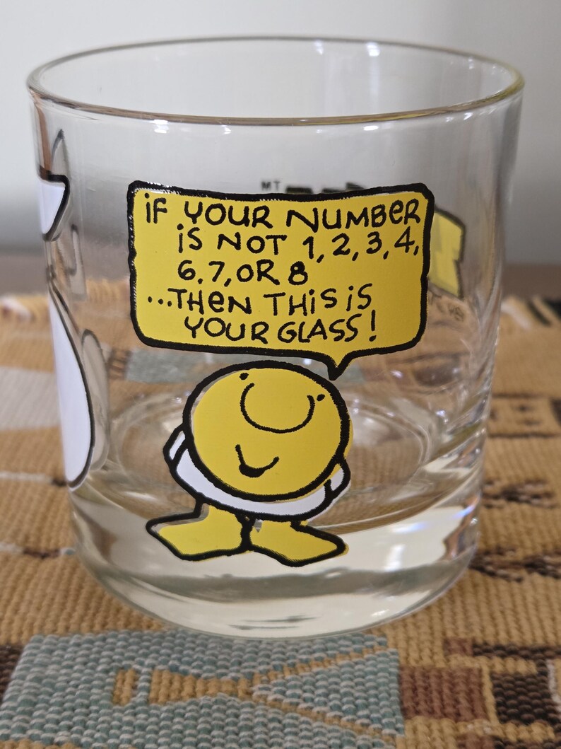 May include: Clear glass with a yellow speech bubble that reads "IF YOUR NUMBER IS NOT 1,2,3,4, 6,7,OR 8...THEN THIS IS YOUR GLASS!". A cartoon character is at the bottom of the glass.