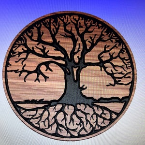 Puede incluir: Un colgante de pared circular de madera con una silueta negra de un árbol de la vida con intrincadas ramas y raíces.