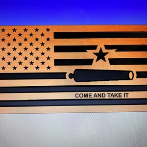 Puede incluir: Bandera de madera con el diseño de la bandera de Texas, con estrellas, rayas y un cañón. Las palabras "COME AND TAKE IT" se muestran debajo del cañón. La bandera está hecha de madera marrón claro con detalles en negro.