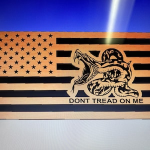 Pode incluir: Uma bandeira americana de madeira com uma cascavel preta e o texto "DONT TREAD ON ME".