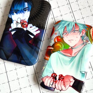 Op de afbeelding: Twee rechthoekige, glanzende kunstwerken in anime-stijl. Eén toont een personage met blauw haar en een rode edelsteen, de andere met turkoois haar en houdt twee rode edelstenen vast. Beide hebben gedetailleerde gelaatstrekken en donkere kleding.