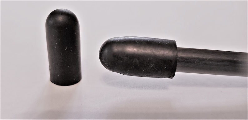 May include: Two black rubber end caps for a rod or pole. One end cap is on a black rod.