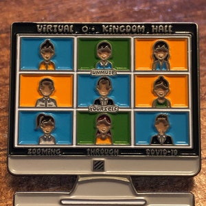 May include: A pin badge in the shape of a computer monitor, with a black frame. The screen shows nine small boxes with cartoon figures. Text on the pin reads "Virtual O Kingdom Hall", "Unmute Yourself", and "Zooming Through Covid-19".