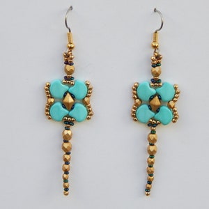 Peut inclure: Une paire de boucles d'oreilles en perles turquoise et dorées avec un motif carré et une longue goutte pendante.
