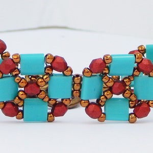 Könnte beinhalten: Ein türkisfarbenes und kupferfarbenes Armband mit roten Akzenten. Das Armband besteht aus kleinen quadratischen und runden Perlen.