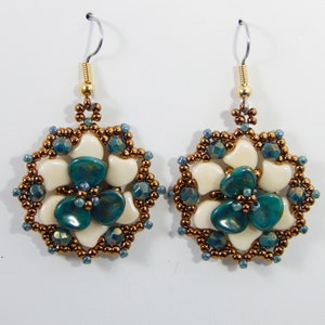 Peut inclure: Une paire de boucles d'oreilles pendantes avec un motif floral. Les boucles d'oreilles sont faites de perles blanches et bleu sarcelle et de perles de couleur cuivre. Les boucles d'oreilles ont un crochet doré.