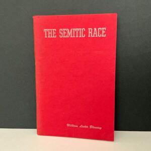 May include: A red book titled "THE SEMITIC RACE" in white capital letters. The author's name, William Lester Blessing, is printed in small white letters at the bottom of the book. The book is standing upright against a black background.