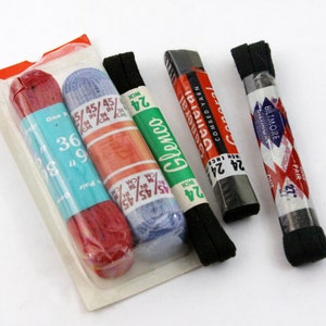 Puede incluir: Cuatro paquetes de cordones de diferentes colores y marcas. El paquete rojo dice "Glenco" y tiene el tamaño "24" impreso. El paquete azul dice "Glenco" y tiene el tamaño "24" impreso. El paquete negro dice "General Combed Yarn" y tiene el tamaño "24" impreso. El otro paquete negro dice "Biltmore" y tiene el tamaño "24" impreso.