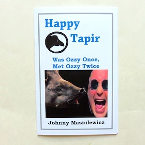 May include: A book cover with a blue and white title "Happy Tapir" and the subtitle "Was Ozzy Once, Met Ozzy Twice". The cover features a black and white illustration of a tapir and a photo of a man with sunglasses and an open mouth.
