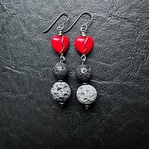 May include: A pair of dangle earrings with red heart-shaped beads and black lava rock beads.