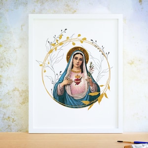 May include: A framed print featuring a religious illustration of a woman with a halo, wearing a blue robe and holding a heart. The image is surrounded by a gold and gray floral wreath. The frame is white.