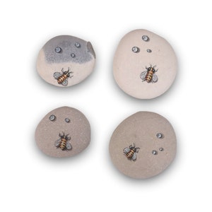 Hand painted stone, a bee resting on a stone with water drops. Fine art. Thumbnail