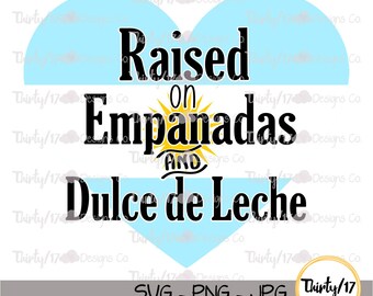 May include: A graphic design featuring the text "Raised on Empanadas AND Dulce de Leche" in a bold, black font. The text is set against a light blue heart shape and a white background. The design includes the text "SVG - PNG - JPG".