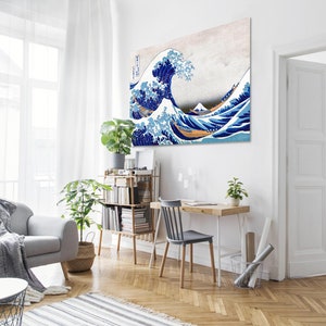 Puede incluir: Un interior de sala de estar con un sof&aacute; gris, una mesa de caf&eacute;, una estanter&iacute;a, un escritorio con una silla y tres impresiones enmarcadas en las paredes. Las impresiones son de una ola, un campo de flores y un estanque con nen&uacute;fares.