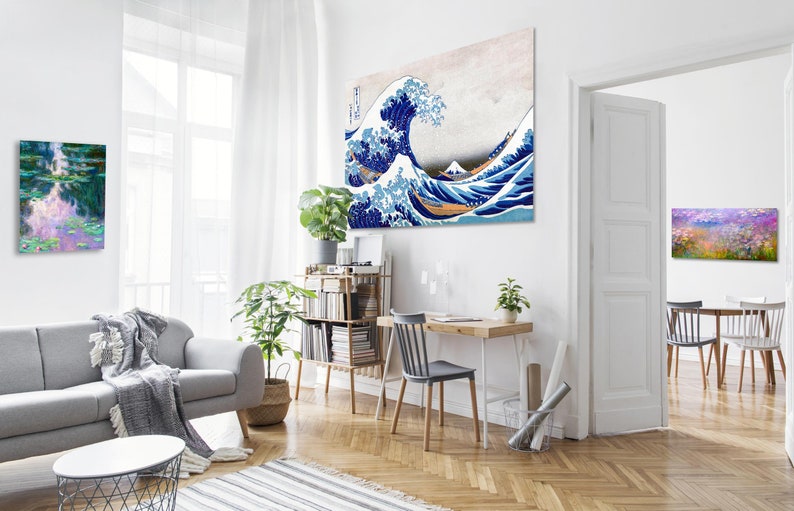 Puede incluir: Un interior de sala de estar con un sof&aacute; gris, una mesa de caf&eacute;, una estanter&iacute;a, un escritorio con una silla y tres impresiones enmarcadas en las paredes. Las impresiones son de una ola, un campo de flores y un estanque con nen&uacute;fares.