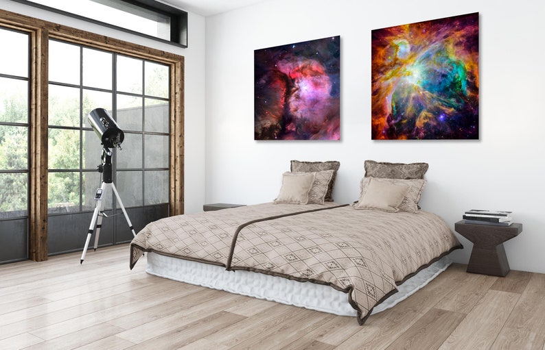 Puede incluir: Un interior de dormitorio con una cama, dos almohadas, una mesita de noche y un telescopio. Dos im&aacute;genes enmarcadas de nebulosas coloridas cuelgan en la pared sobre la cama.