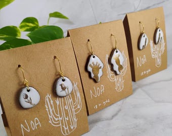 Handgemaakte keramische oorbellen bruine klei wit glazuur gouden cactusdecoratie