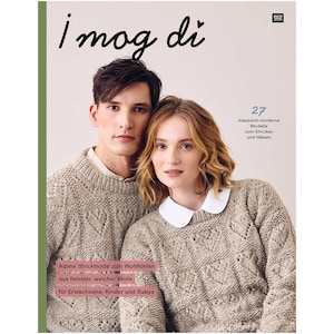 May include: A magazine cover featuring a couple wearing knitted sweaters. The magazine is titled "I mog di" and has the text "Alpine Strickmode zum Wohlfühlen. aus feinster, weicher Wolle für Erwachsene, Kinder und Babys" and "27 klassisch-moderne Modelle zum Stricken und Häkeln".